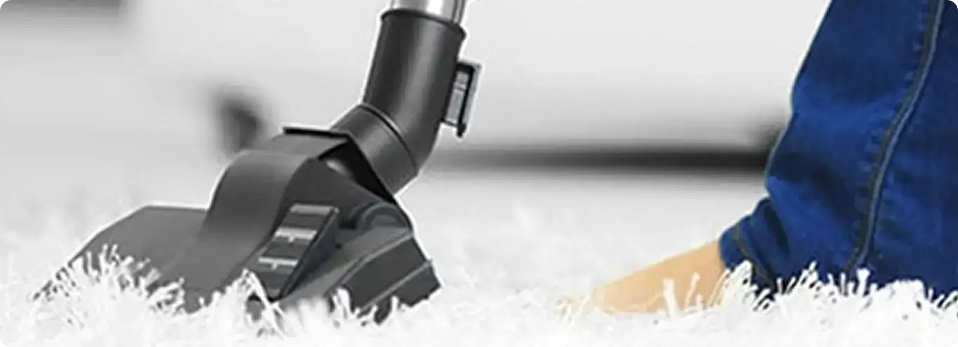 Close-up of a professional vacuuming a white carpet in Wyoming.